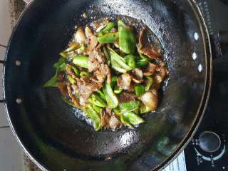 妈妈拿手菜——回锅肉,翻炒5-8分钟，让肉和青椒上色，熟透。