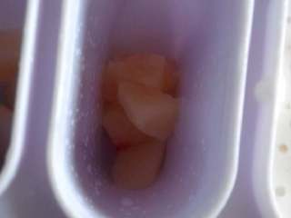 蜜桃酸奶冰棒,准备好冰棒模具，加少许桃子块，再倒入桃子酸奶糊