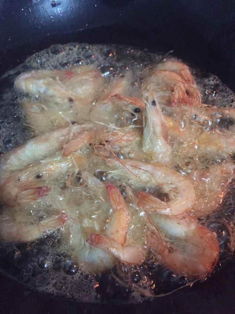 朱记虾蟹煲,把处理干净的虾蟹拍上生粉，锅里热油，虾炸锅炸至变色捞出备用