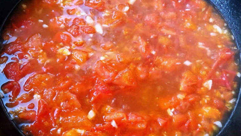 番茄炒鱼片,锅中倒入底油加热放入蒜粒爆香再放入切好的番茄炒碎出汤汁添加适量清水