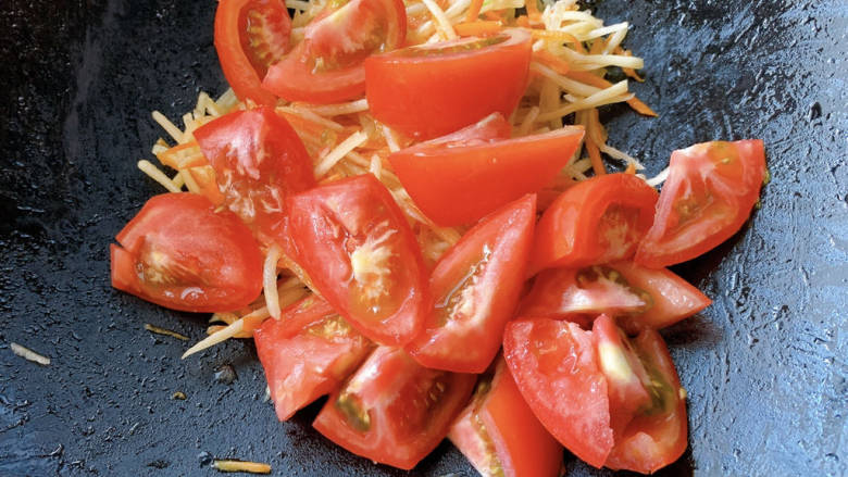 西红柿炒土豆丝,炒至土豆丝些许变软后，加西红柿块进去翻炒