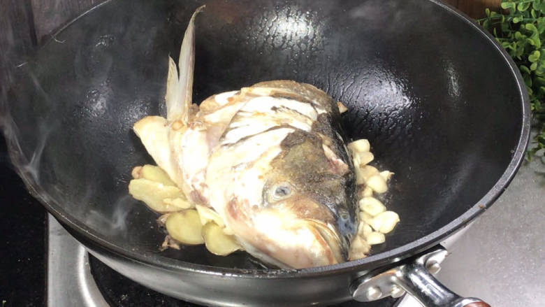 鱼头炖汤,煎至两面金黄，放入姜蒜爆香