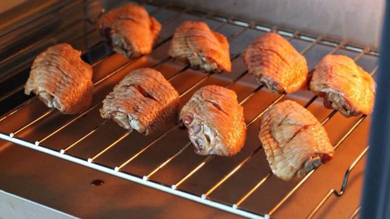 蜂蜜鸡翅,烤箱提前上下火200度预热，将鸡翅排放在烤网上放进烤箱中层烤约十分钟，取出在鸡翅在正反面刷上<a style='color:red;display:inline-block;' href='/shicai/ 865'>蜂蜜</a>，回炉继续烤制。