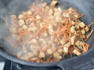 酸菜烤包子,加入胡萝卜丝继续快速翻炒片刻。