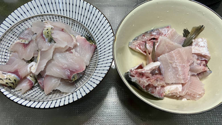 金汤鱼,鱼骨剁成块，清洗干净沥水备用。
鱼肉片成四五毫米厚的鱼片，不要切的太薄，草鱼肉太薄煮出来容易碎。清水中加入食盐，加入鱼肉抓洗几遍，洗去血水用厨房纸巾吸去表面水分