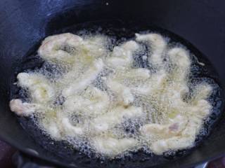 柠檬鸡柳,锅中倒入适量食用油烧至七八成热，改中小火一根一根地下入鸡肉条，炸至定型后再翻动，捞出控油。