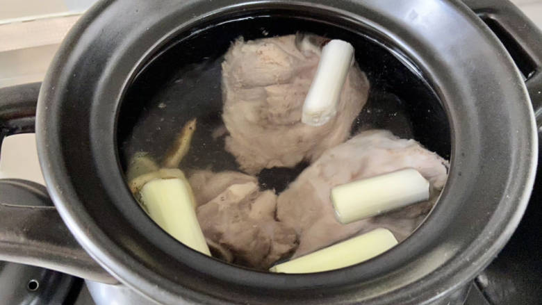胡萝卜筒骨汤,取一个深砂锅或者珐琅锅等汤锅，加入适量清水（我加了大概3升），加入焯水洗净的筒骨，剩下的姜片，葱段，