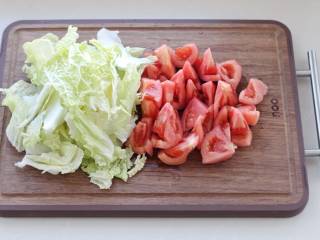 红焖牛肉煲,番茄顶部划十字刀，放进沸水中烫去外皮切成块状，白菜直接撕成小片即可。