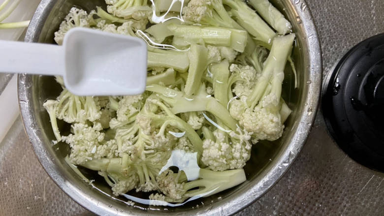 椒盐花菜,花菜掰成小朵，比较脆的梗可以一切两半，加入少许盐，清水浸泡十分钟