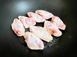 雪碧鸡翅,锅中倒入适量的食用油烧热，放入鸡翅