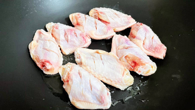 雪碧鸡翅,锅中倒入适量的食用油烧热，放入鸡翅