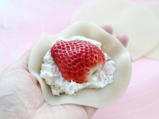 草莓雪媚娘,取一张饼皮在中间放适量淡奶油，然后放一颗草莓，上面再盖一层淡奶油。