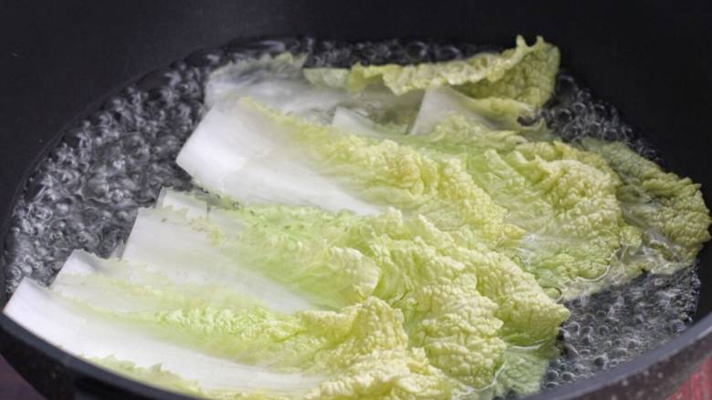 白菜卷肉,白菜叶前面根部位置切掉，放进沸水中烫软，捞出过凉水挤去多余水分。