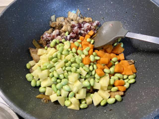 五花肉焖饭,加入香肠，土豆，胡萝卜，毛豆，中火翻炒一分钟