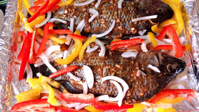 香烤鲫鱼,将酱料刷在鱼身上，放入蔬菜，再放入少许黑胡椒酱拌匀。预热烤箱，200度烤30分钟。