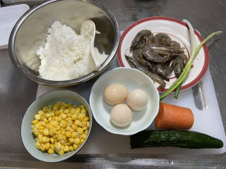 玉米虾仁蛋炒饭,食材合照：剩米饭300g，虾8个，熟玉米粒一小碗，鸡蛋三个，胡萝卜一小节，黄瓜半根，小葱两根