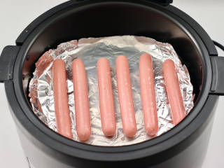 风味火腿肠,空气炸锅提前预热，炸篮铺上锡纸放入火腿肠。