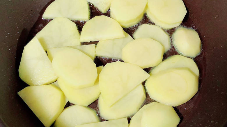 土豆回锅肉,锅中倒入油，放入土豆片，两面煎至金黄。