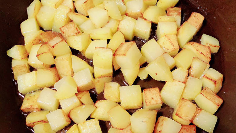 素炒双丁,锅中倒入油，放入土豆慢煎至焦黄。