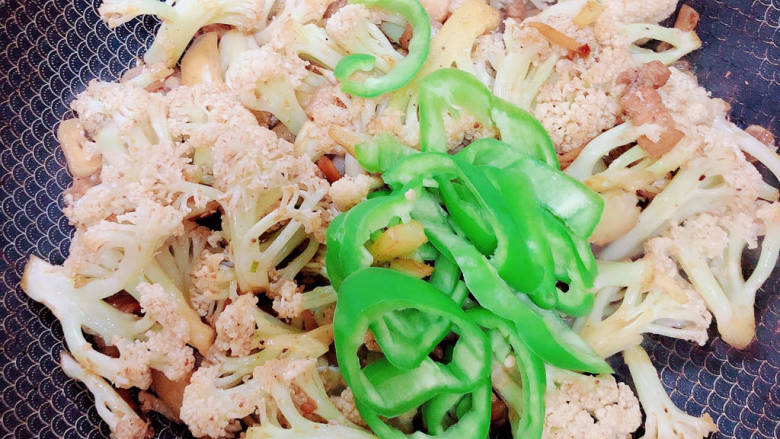 干锅菜花五花肉,加入尖椒丝，翻炒均匀。