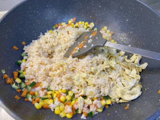 玉米虾仁蛋炒饭,加入炒好的鸡蛋和米饭，中火翻炒均匀