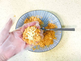 芝士烤红薯,戴上手套，取一块红薯泥，在手心按压成圆形，中间加入马苏里拉芝士