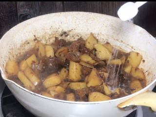 土豆烧牛筋,10分钟后打开锅盖，炒匀，淋入生抽、加入味精拌匀