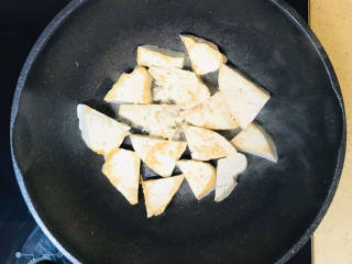 虾仁豆腐煲,锅里加油烧热，码放进豆腐块，慢火煎至金黄色，捡出来备用