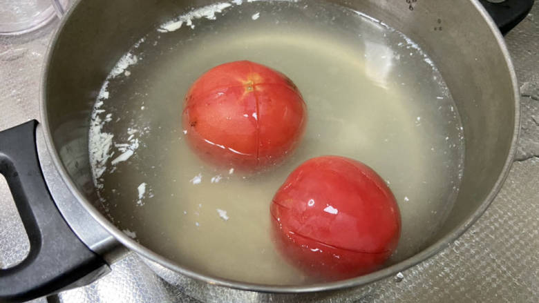 西红柿炒土豆丝,番茄表面化十字花刀，开水浸泡三分钟，以便剥皮。阿晨偷懒，食用刚焯豆腐的开水浸泡的，