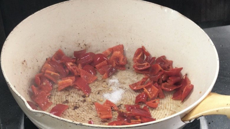 辣椒毛豆炒午餐肉,就着油锅，放入红辣椒炒匀，加盐炒香