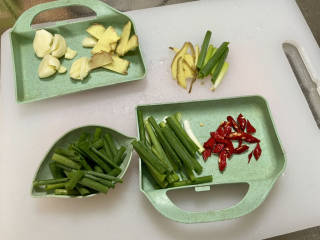 红烧草鱼块,蒜剥皮拍一下，姜洗净切片，小葱洗净葱白葱叶分别切段，小米辣洗净切段
