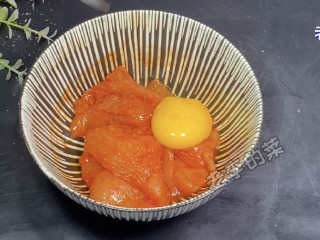 迷你鸡蛋小汉堡制作教程,腌制好的鸡肉中加一个蛋黄抓拌均匀。