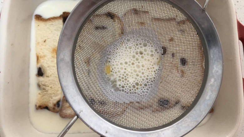 法式牛奶烤吐司,然后将牛奶鸡蛋液过滤，倒入烤盘中。