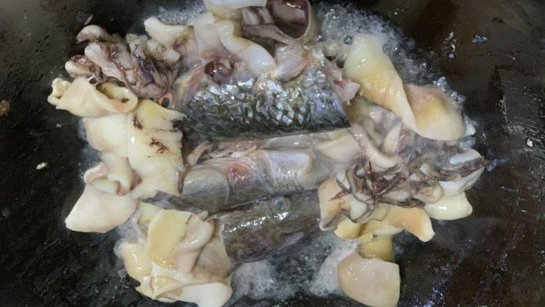 鱼头炖汤,锅里放油放鱿鱼和鱼头