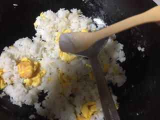 玉米虾仁蛋炒饭,倒入米饭翻炒，加入适量盐，多炒一会，干点好吃