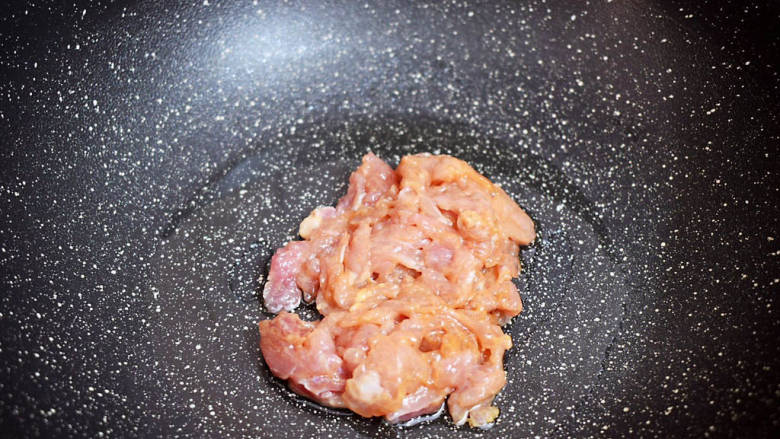 茼蒿炒肉丝,锅中倒入适量的食用油烧热，放入猪肉