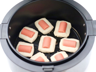 快手火腿小酥饼,空气炸锅提前预热，把火腿小酥饼胚放入炸篮中。