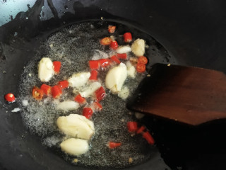 家常炒螃蟹,可以把蒜和小米椒先扔进锅中炒香，然后再加绿叶葱稍微一翻炒。