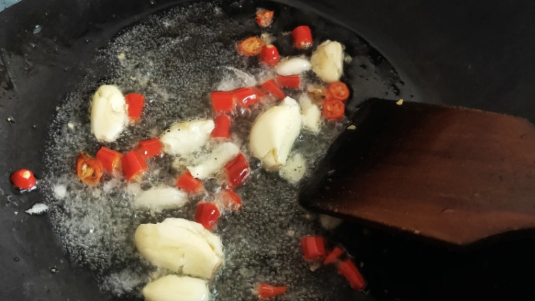 家常炒螃蟹,可以把蒜和小米椒先扔进锅中炒香，然后再加绿叶葱稍微一翻炒。