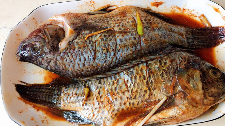 香烤鲫鱼,将鱼与腌料按摩一会儿入味。