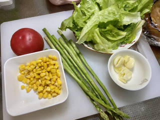 鸡胸肉蔬菜沙拉,番茄清洗，芦笋削去老根洗净，生菜叶洗净，蒜剥皮