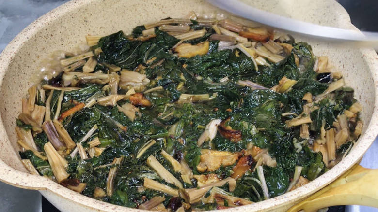 家常焖梅干菜,加入适量清水，煮沸后转中火，盖上锅盖炖煮20分钟左右