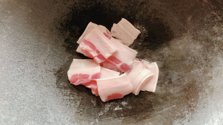 干锅菜花五花肉,锅烧热，加入切成薄片的五花肉，入锅中煸炒出油脂。
