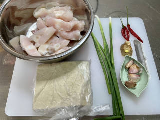 红烧草鱼块,食材合照：处理好的草鱼块一斤，卤水豆腐一块，小葱三根，小米辣三个，姜一块，蒜四瓣