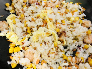 玉米虾仁蛋炒饭,倒入炒好的鸡蛋块炒匀。