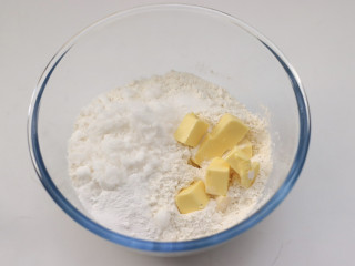 蔓越莓司康,容器里加入低筋面粉➕零克糖➕盐➕泡打粉搅拌均匀后，放入软化的黄油。