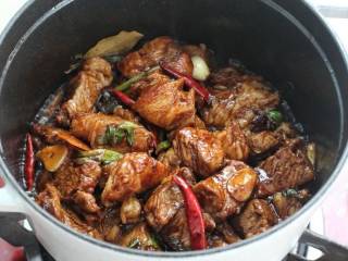 红烧羊肉煲,再调入一勺料酒、黄豆酱、生抽和老抽翻炒至羊肉上色。