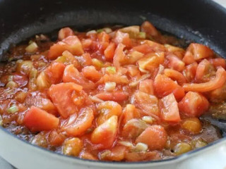 金针菇番茄汤,接着放入番茄块翻炒均匀，倒入番茄酱小火炒出汤汁。