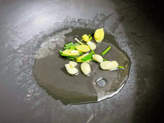 黄瓜炒鱿鱼,锅中倒入适量的食用油烧热，放入葱姜蒜爆香