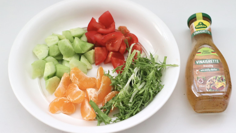 红肠沙拉水果时蔬,容器里放入苦苣和橘子，黄瓜和番茄，倒入香草沙拉酱。